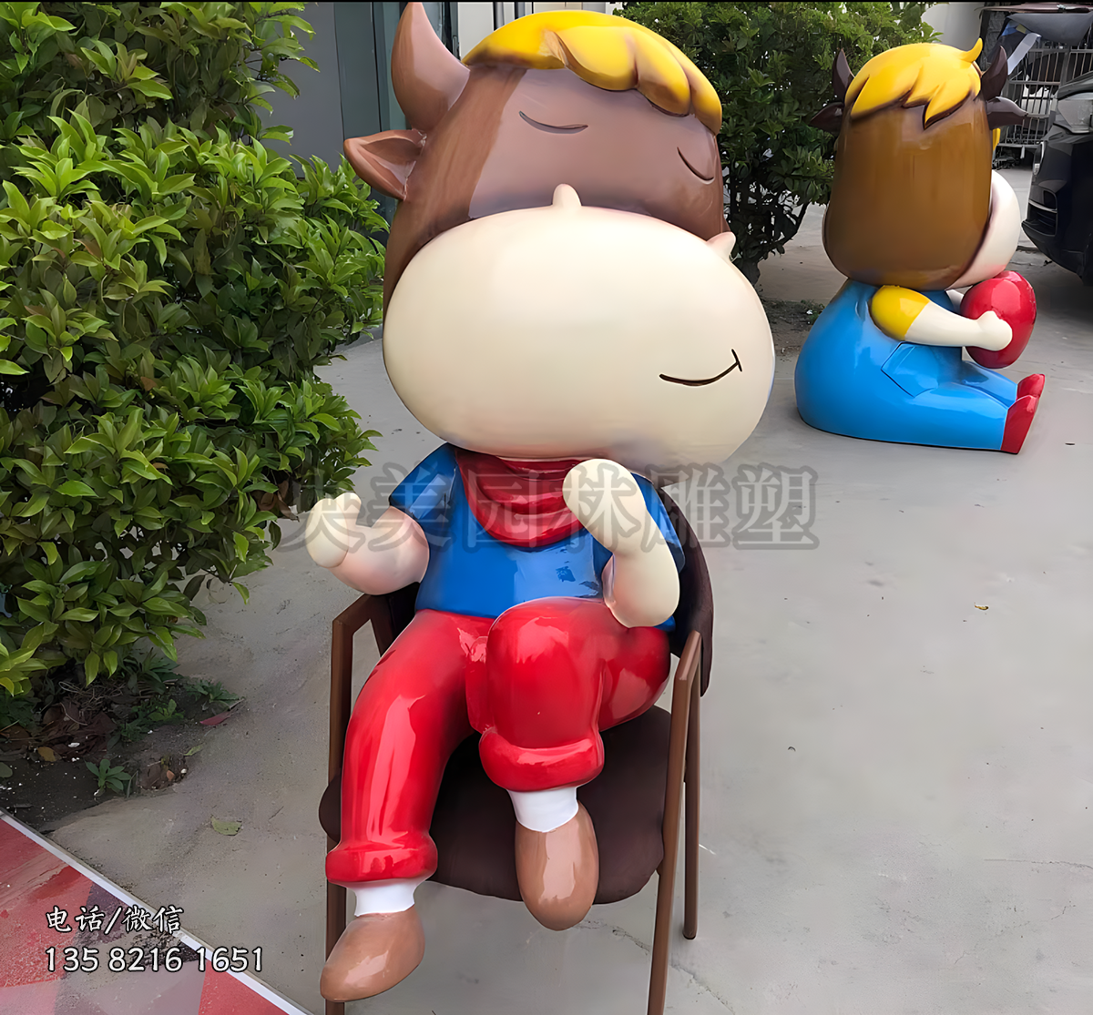 坐椅子上的卡通造型牛雕塑